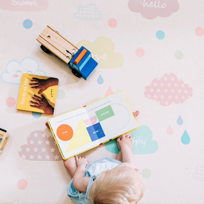 a toddler playing with interactive toys on a colorful play mat 