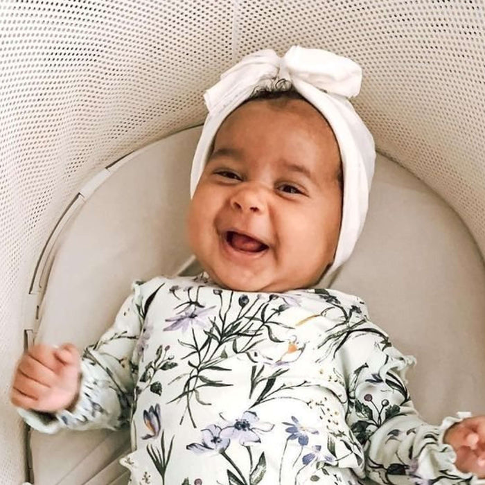 baby smiling while in a bassinet 