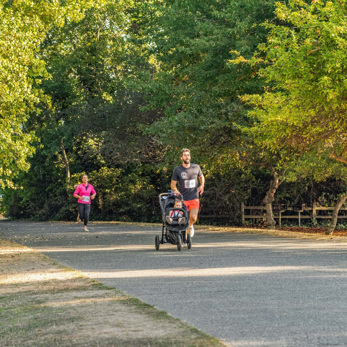 dad jogging with his little one in a jogging stroller