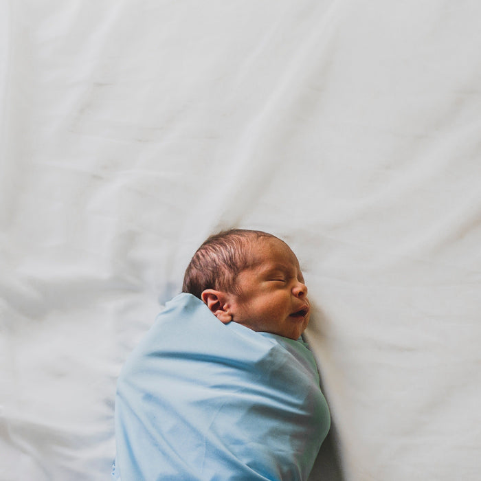 a baby sleeping safely in a swaddle 