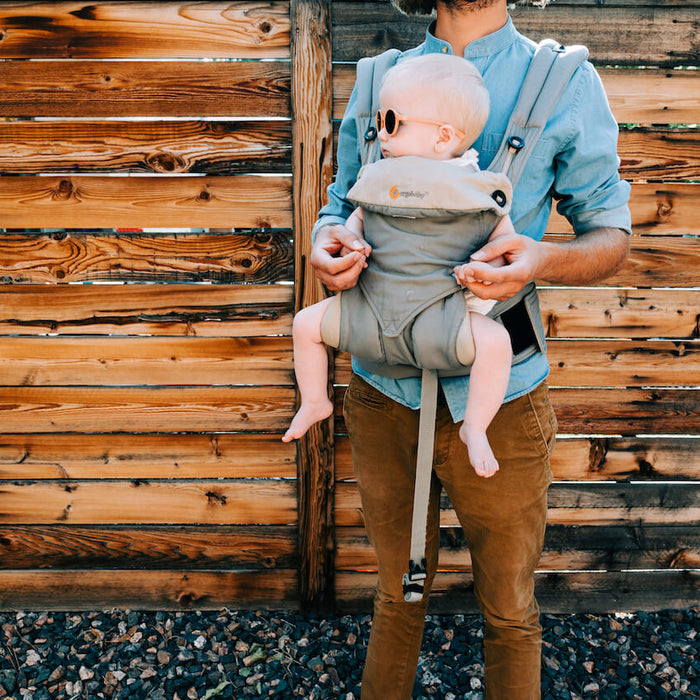 dad holding his baby in a structured carrier 