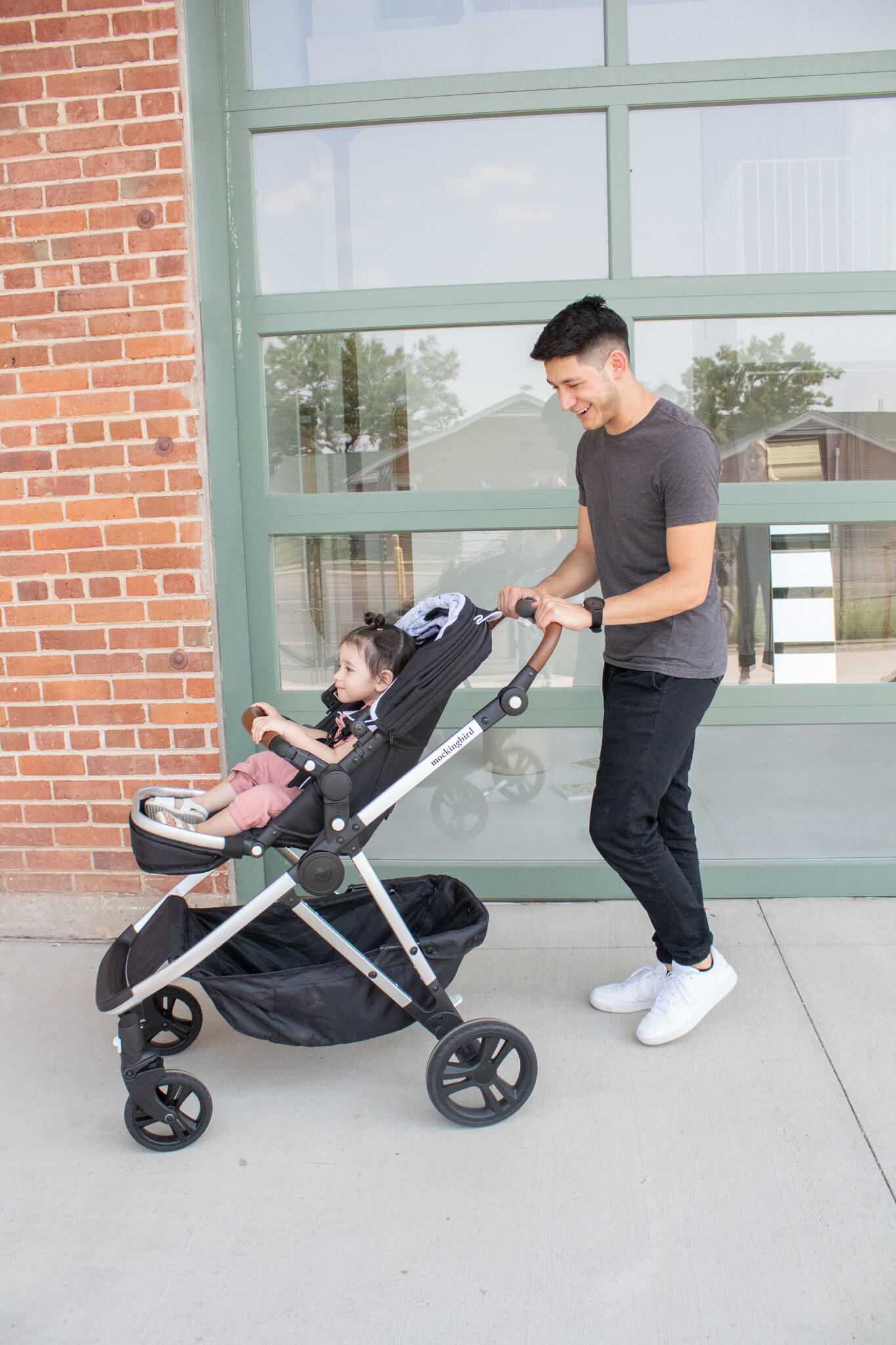 A tall father pushing his daughter in the UPPAbaby Vista 